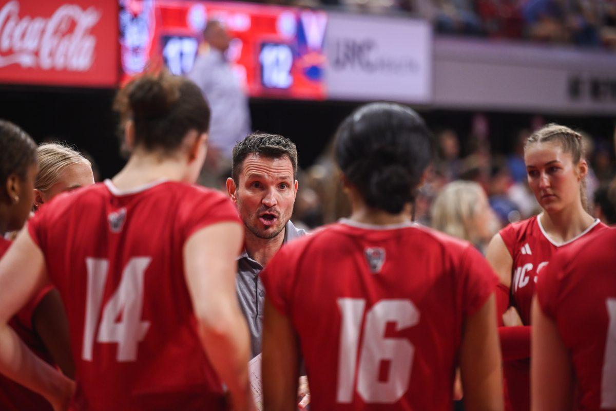 NC State women's volleyball head coach Luka Slabe communicates strategy to the team during a timeout in the Wolfpack's home game against the Virginia Cavaliers at Reynolds Coliseum on Sunday, Sept. 29, 2024. NC State went on to win against Virginia 3-1.