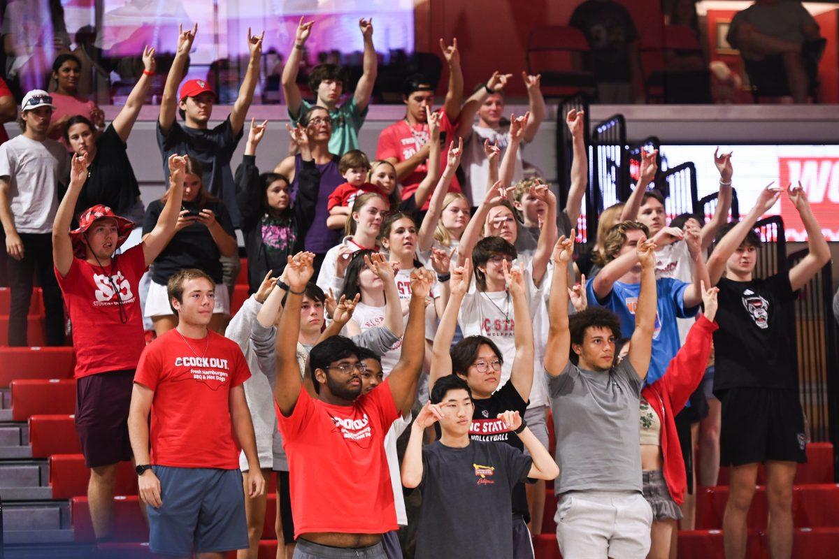 NC State students cheer on the NC State women's volleyball team near the end of the Wolfpack's home game against the Virginia Cavaliers at Reynolds Coliseum on Sunday, Sept. 29, 2024. NC State went on to defeat Virginia 3-1.