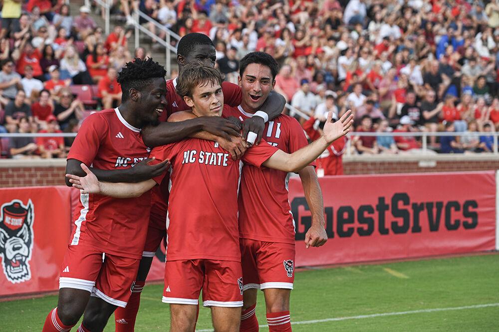 (From left to right) Senior defender Yves Tcheuyap, sophomore forward Hakim Karamoko and senior forward Henrique Santos congratulate junior midfielder Taig Healy after his goal during the match against Duke University at Dail Soccer Field on Friday, Sept. 27, 2024. The Wolfpack lost to the Blue Devils 2-1.