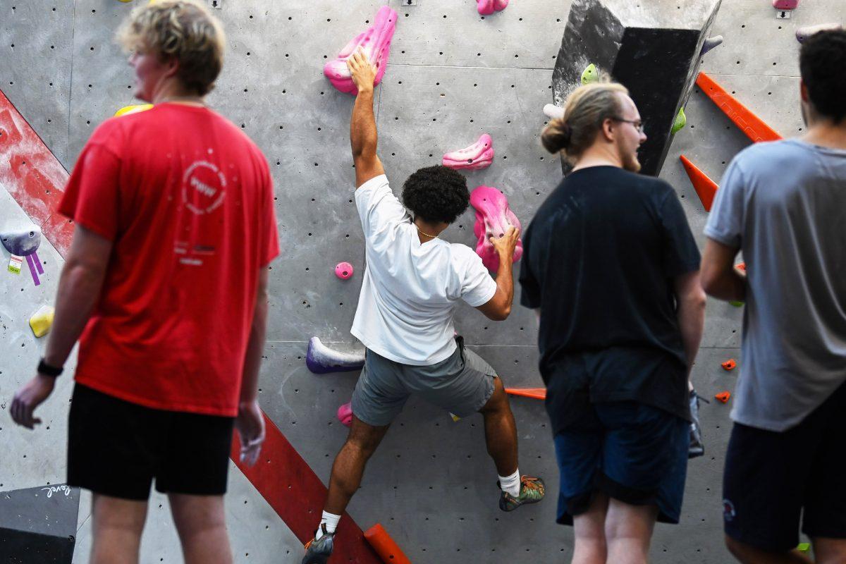 Students wait for an opening on the rock climbing wall at Carmichael Gymnasium on Wednesday, Sept. 18, 2024. The climbing center has a maximum capacity of 60 people and is often crowded in the evening.