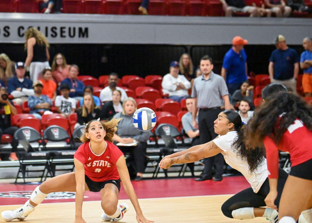 Graduate setter Naomi Cabello and graduate libero Skye Stokes dive for the ball during the match against Virginia in Reynolds Coliseum on Sunday, Sept. 29, 2024. NC State beat Virginia 3-1.