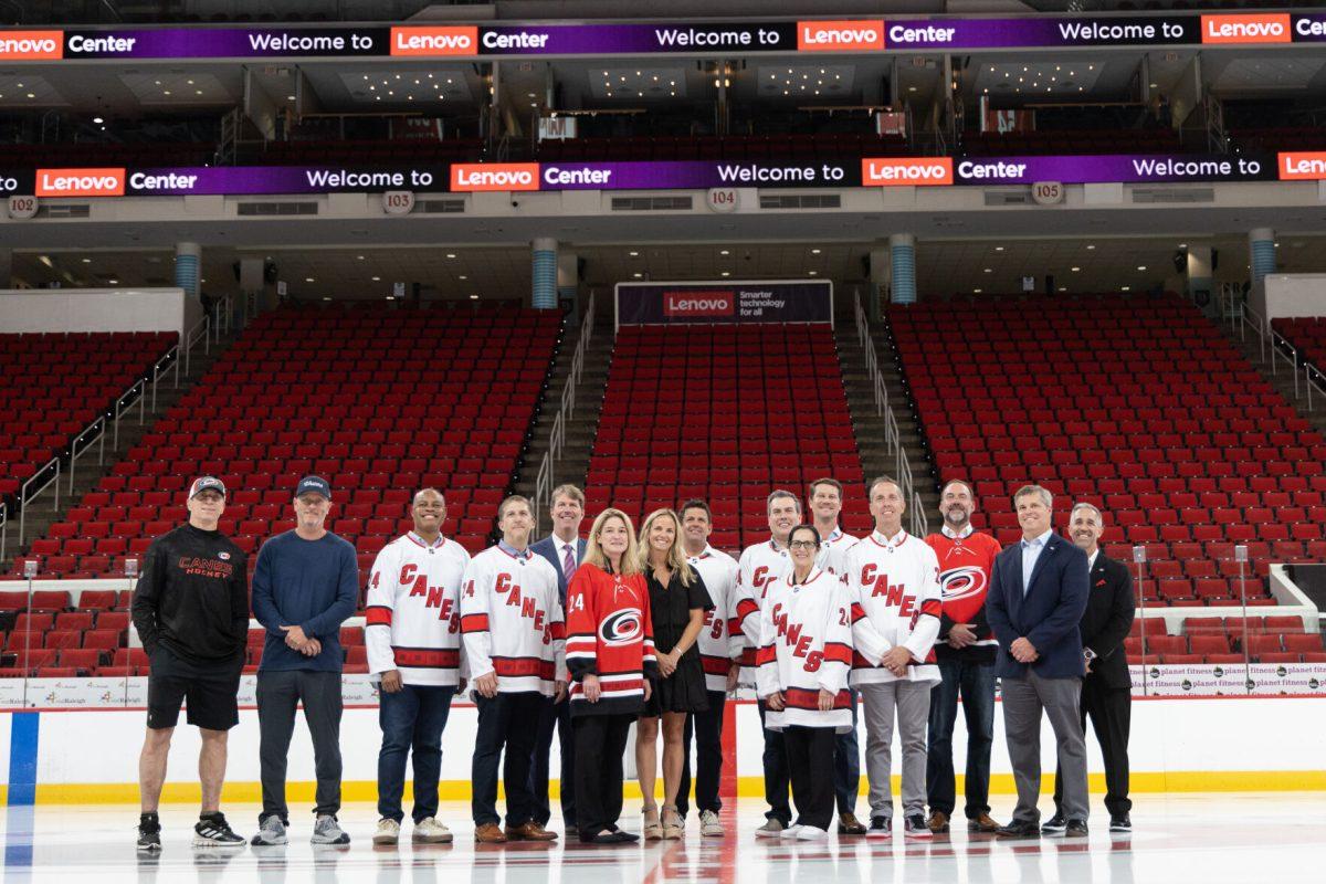 Carolina Hurricanes head coach Rod Brind'Amour and Tom Dundon Lenovo executives and pose on the ice at the Lenovo Center unveiling on Thursday, Sept. 19, 2024. Lenovo&#8217;s naming rights agreement runs for 10 years throughout the 2033-2034 NHL season.