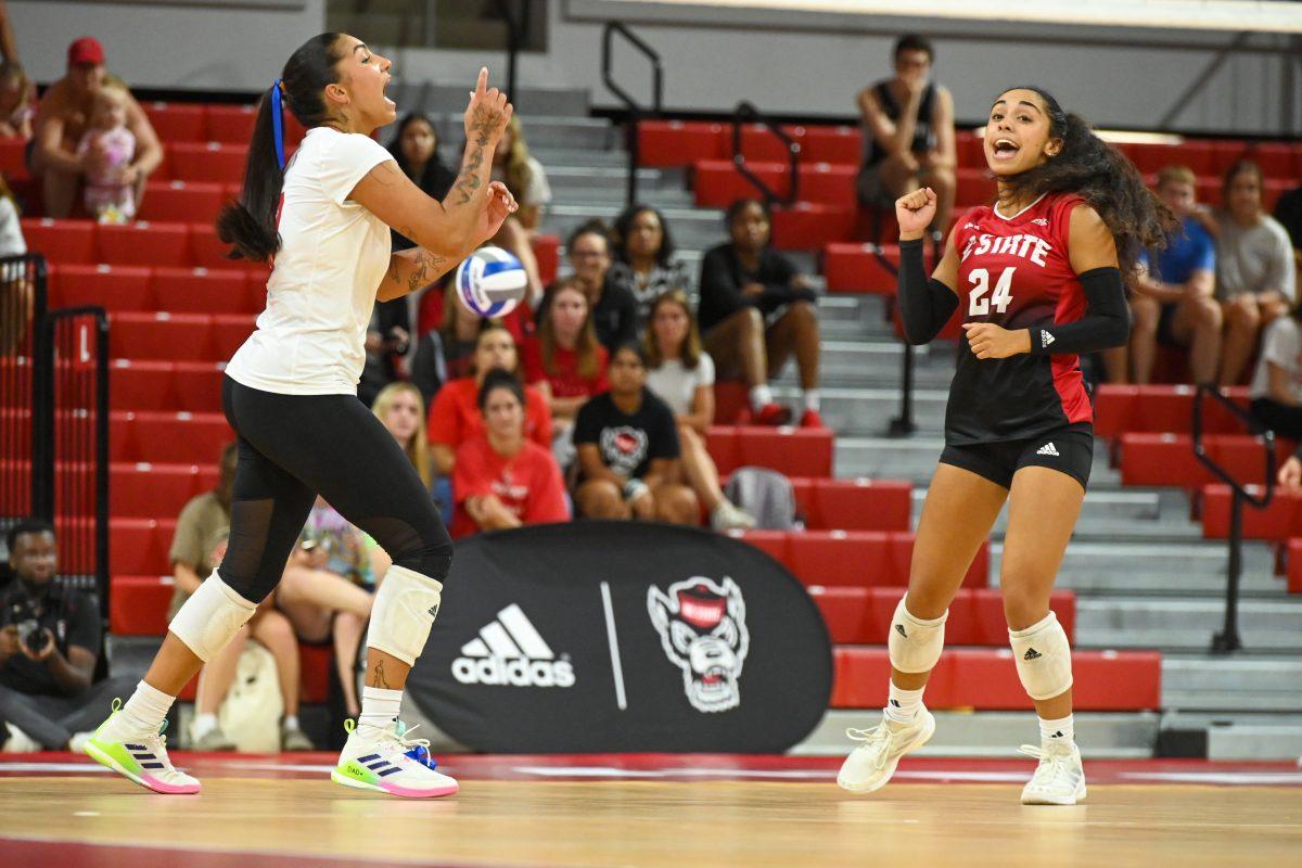 Graduate libero Skye Stokes and junior defensive specialist Sydney Daniels celebrate the point during the match against Liberty in Reynolds Coliseum on Wednesday, Sept. 11, 2024. Stokes made 15 digs. Daniels made nine digs. The Wolfpack defeated the Flames 3-1.