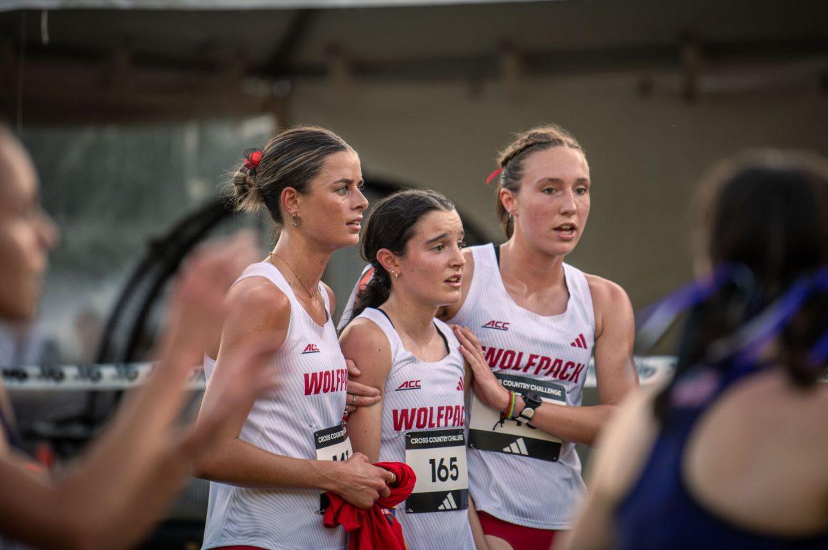 Juniors Grace Hartman (right) and Hannah Gapes (left) support freshman Ellie Shea (middle) during the Adidas XC Challenge at WakeMed Soccer Park on Friday, Sept. 20, 2024. Hartman finished with a time of 16:25.1, Gapes with 16:26.5, and Shea with 17:39.4. The NC State women's team finished in first place with a total of 34 points.