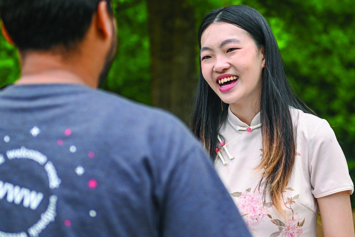 Xinyuan Cai, a second-year studying business administration with a concentration in marketing, speaks to a participant while tabling with the Chinese Students &amp; Scholars Friendship Association during International Festival at Stafford Commons on Friday, April 19, 2024. This event featured tabling from various culturally focused student organizations.