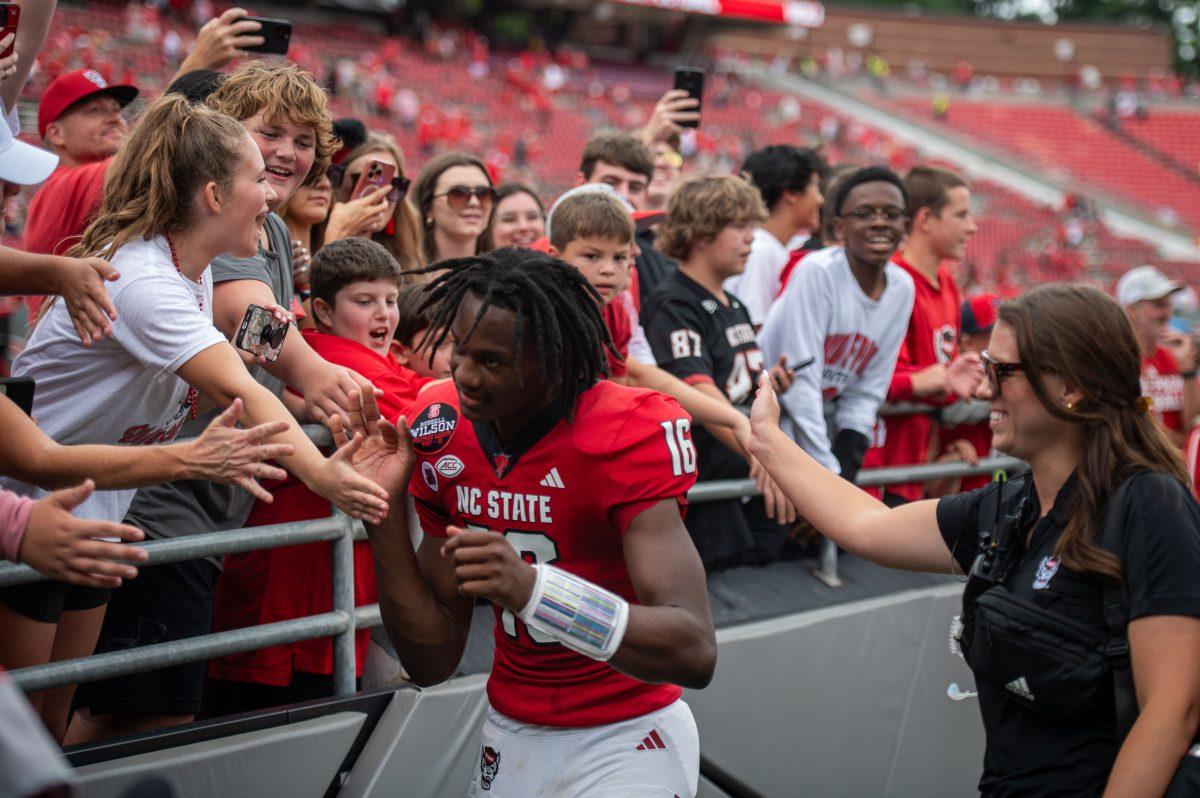 Freshman quarterback C.J. Bailey high-fives fans after the game against LA Tech at Carter-Finley Stadium on Saturday, Sept. 14, 2024. Bailey had 156 passing yards during the game. The Wolfpack beat the Bulldogs 30-20.