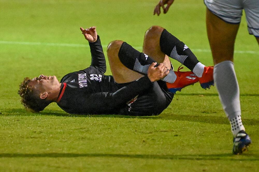 Sophomore midfielder Drew Lovelace lies on the ground after being injured in the match against American at Dail Soccer Field on Tuesday, Oct. 10, 2023. Lovelace made one shot for the Wolfpack. NC State lost to American 2-1.