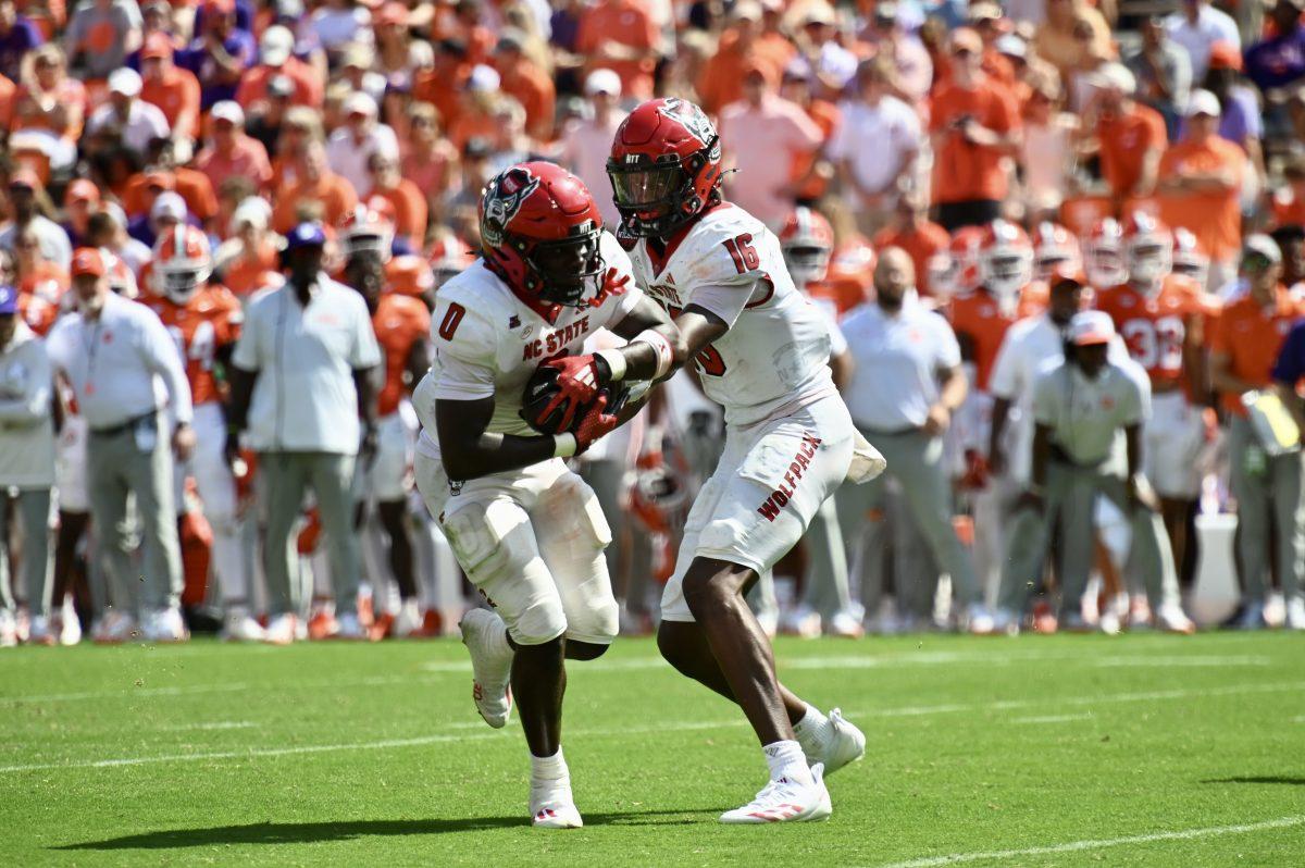 Freshman quarterback CJ Bailey hands off the ball to sophomore running back Kendrick Raphael during the football game against Clemson in Memorial Stadium on Saturday, Sept. 21, 2024. Raphael rushed for 94 yards and scored one touchdown. The Wolfpack lost to the Tigers 59-35.