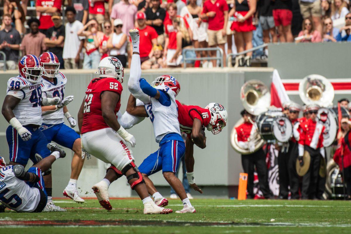 Freshman quarterback C.J. Bailey gets flipped by his opponent during the game against LA Tech at Carter-Finley Stadium on Saturday, Sept. 14, 2024. Bailey had 156 passing yards during the game. The Wolfpack beat the Bulldogs 30-20.