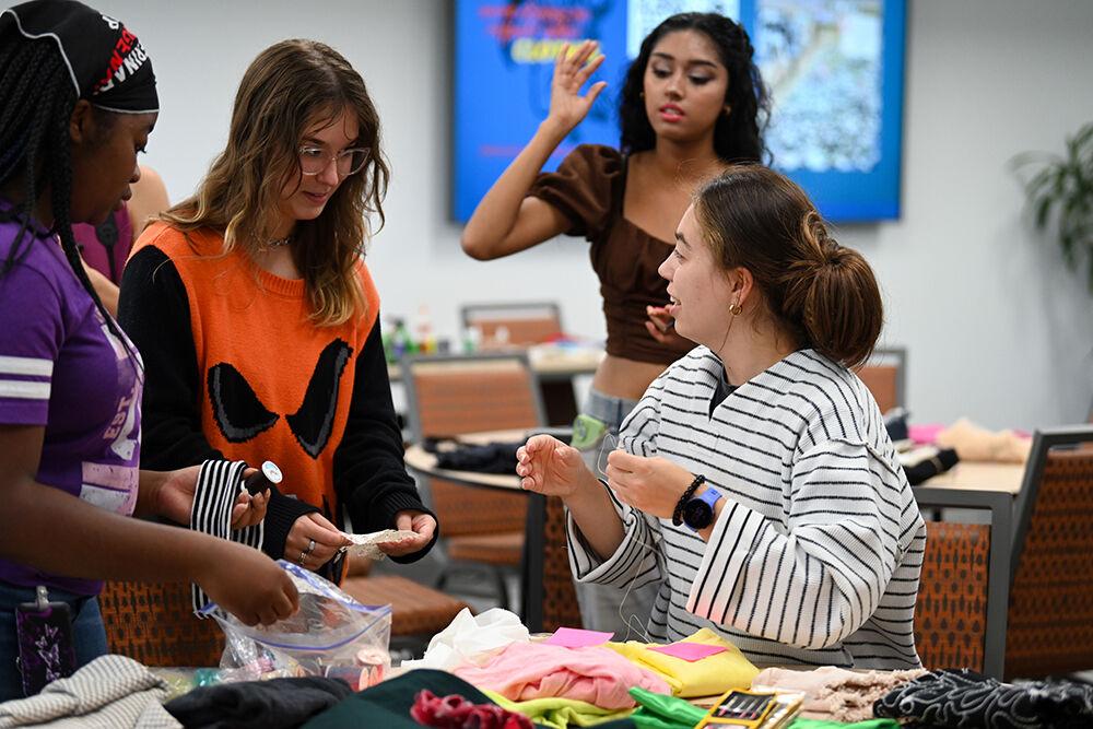 Jada Stewart, a first-year studying engineering, Serenity Stueve, a fourth-year studying environmental science, and Maria Llerenas Soto, a fourth-year studying international studies, pick out costume materials at Spooky Stitches at Witherspoon Student Center on Thursday, Oct. 24, 2024. Spooky Stitches was an event organized by the Sustainability Stewards where students could make Halloween costumes out of reused textiles and clothing.