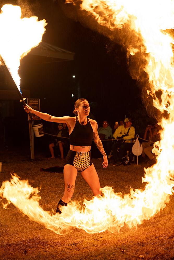 Amber Kornegay swings a fire staff during her performance at the North Carolina State Fair in Raleigh on Thursday, Oct. 25, 2024. Kornegay, a local North Carolinian from Cove City, was one of the many performers putting on a show at the fair.