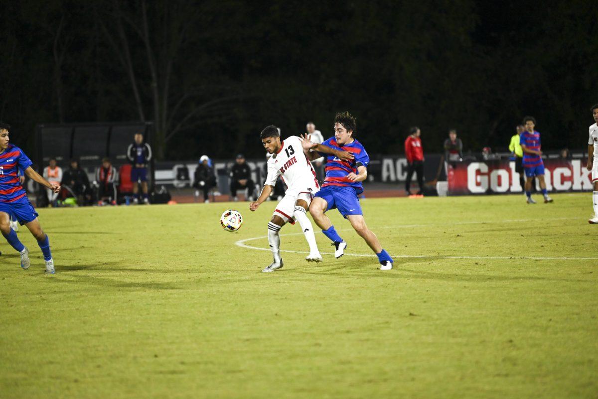 Junior midfielder Calem Tommy shields the ball against a SMU defender at Dail Soccer Field on Saturday, Oct. 19, 2024. NC State beat SMU 5-1.