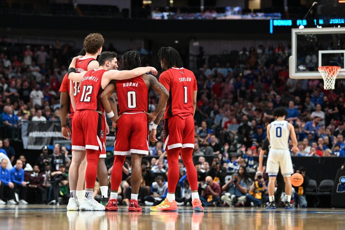 NC State huddles together while Duke freshman guard Jared McCain takes free throws for a technical foul on the NC State bench during the NCAA Tournament Elite 8 game at American Airlines Center in Dallas on Sunday, March 31, 2024. NC State beat Duke 76-64 to advance to the Final Four.
