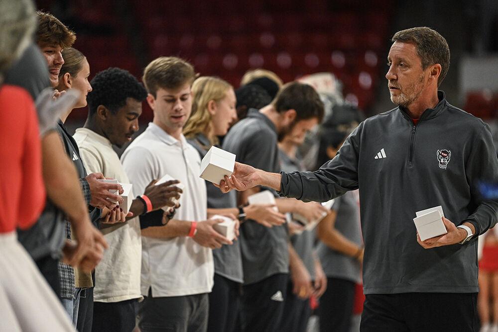 Assistant coach and director of operations Houston Fancher gives a student their ring during the halftime during the exhibition&#160; game against Anderson in Reynolds Coliseum on Tuesday, Oct. 29, 2024. The Wolfpack beat the Trojans 91-54.