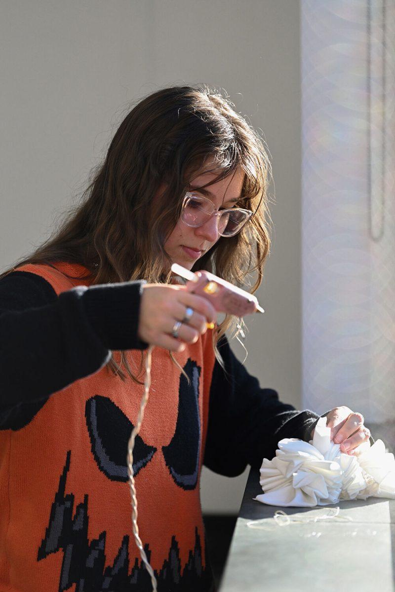 Serenity Stueve, a fourth-year studying environmental science, uses a glue gun to work on a clown collar at Spooky Stitches at Witherspoon Student Center on Thursday, Oct. 24, 2024. Organized by the Sustainability Stewards, Spooky Stitches was an event that encouraged students to make Halloween costumes by upcycling reused textiles and clothing.
