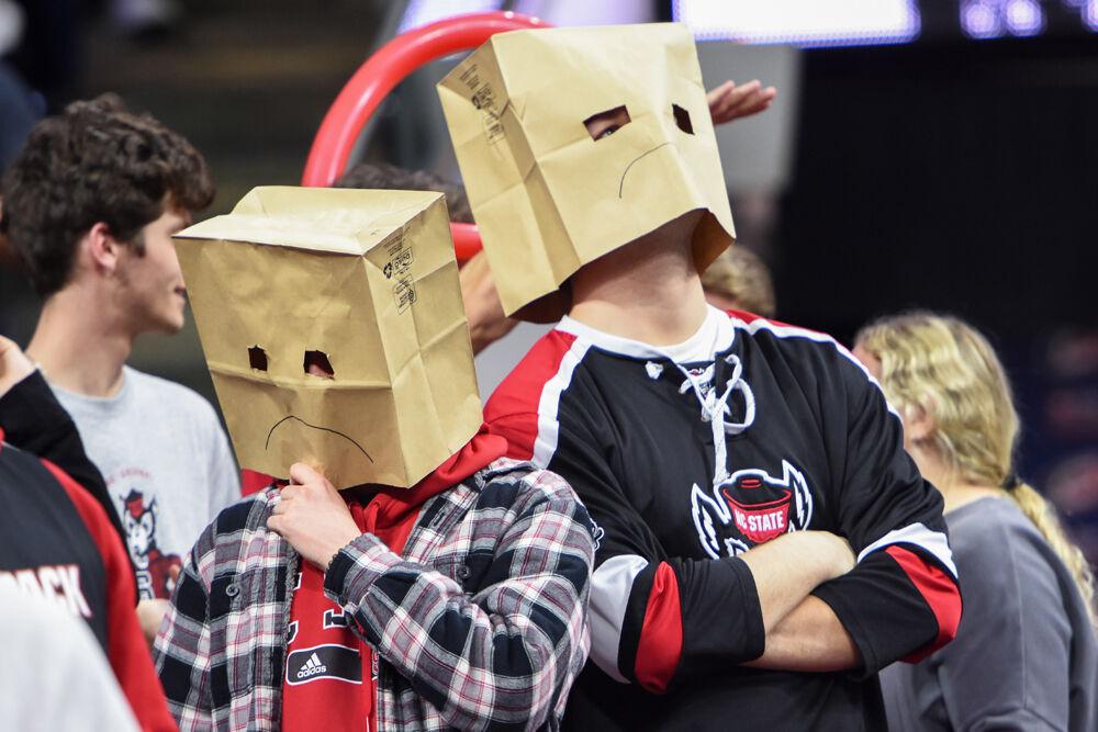 Two NC State students show their disappointment with the men's basketball season by wearing paper bags with a frown during the game against the Wake Forest game in PNC Arena on Wednesday, Feb. 9, 2022. NC State lost 69-51.
