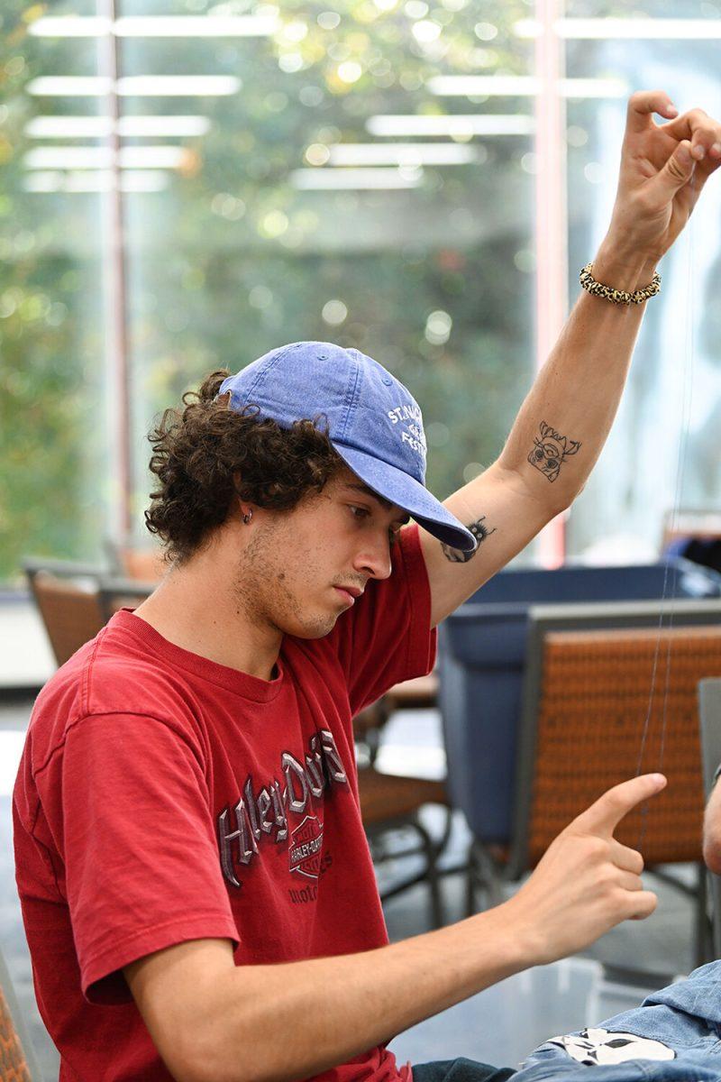 Haze Matthews, a third-year studying film studies, measures out thread at Spooky Stitches at Witherspoon Student Center on Thursday, Oct. 24, 2024. Spooky Stitches was an event organized by the Sustainability Stewards where students could make Halloween costumes out of reused textiles and clothing.