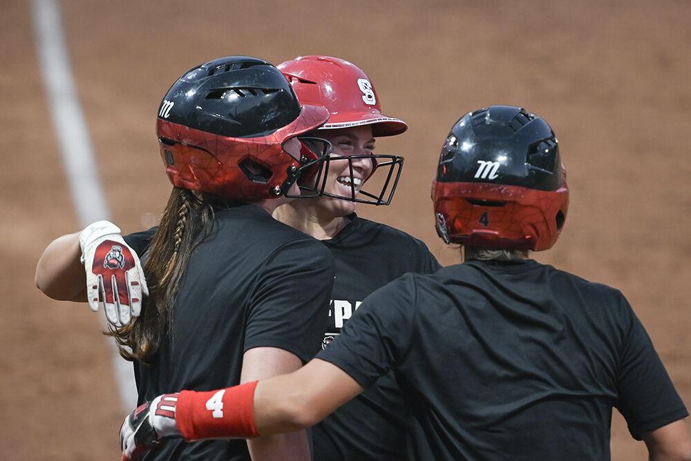 Junior infielder Teagan Thrunk (middle) celebrates with junior outfielder Ellie Goins (left) and sophomore infielder Tori Ensley (right) after scoring a run during the game against Elon at Dail Softball Stadium on Wednesday, Oct. 23, 2024. The Wolfpack won the game 14-7.