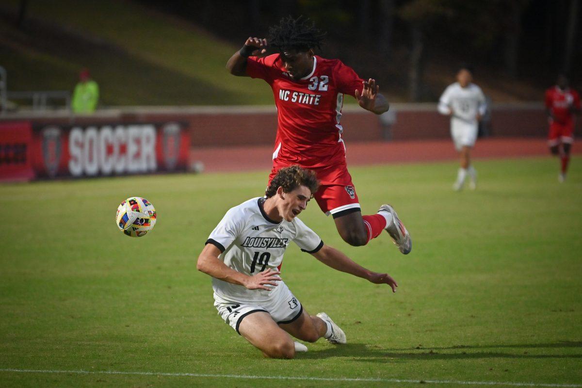 Sophomore forward Donavan Phillip collides with a Louisville defender during the Wolfpack's final home soccer game of the regular season against the Louisville Cardinals at Dail Soccer Field on Sunday, Oct. 27, 2024. The Wolfpack beat the Cardinals 1-0.