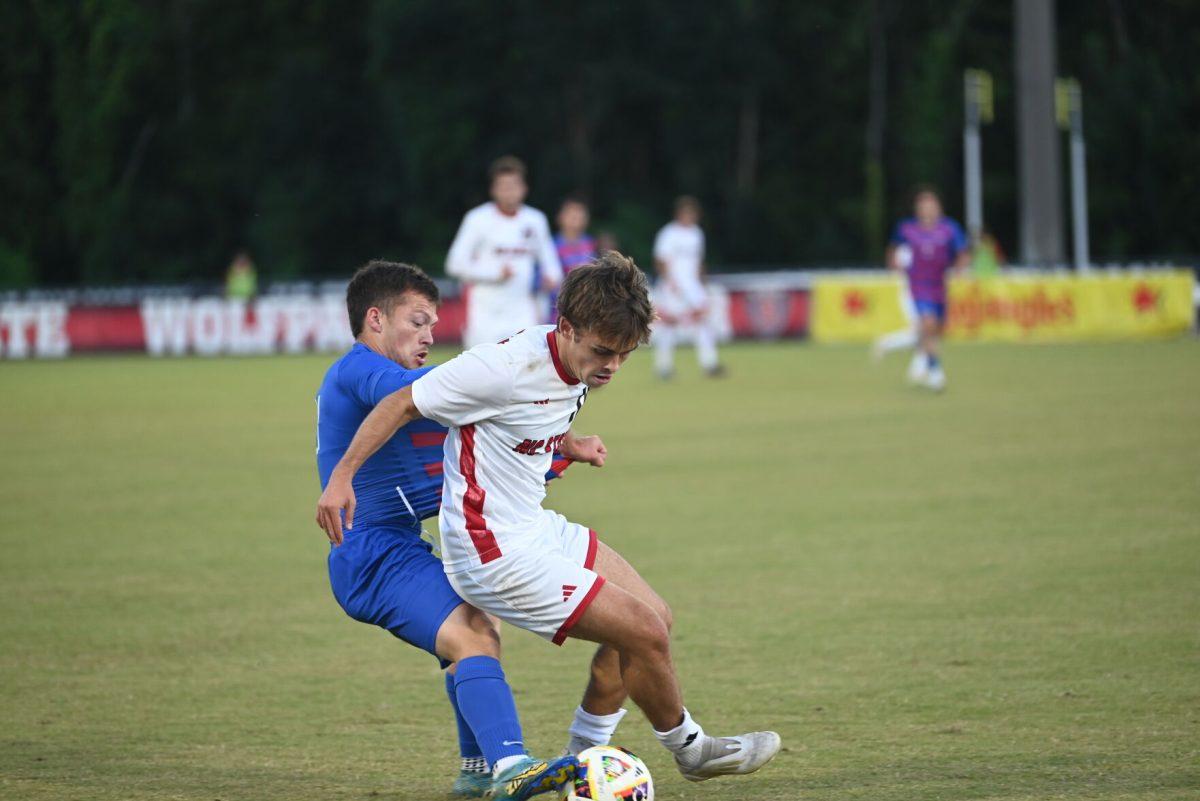 Junior center attacking midfielder Taig Healy shields the ball from a SMU defender at Dail Soccer Field on Saturday, Oct. 19, 2024. NC State beat SMU 5-1.