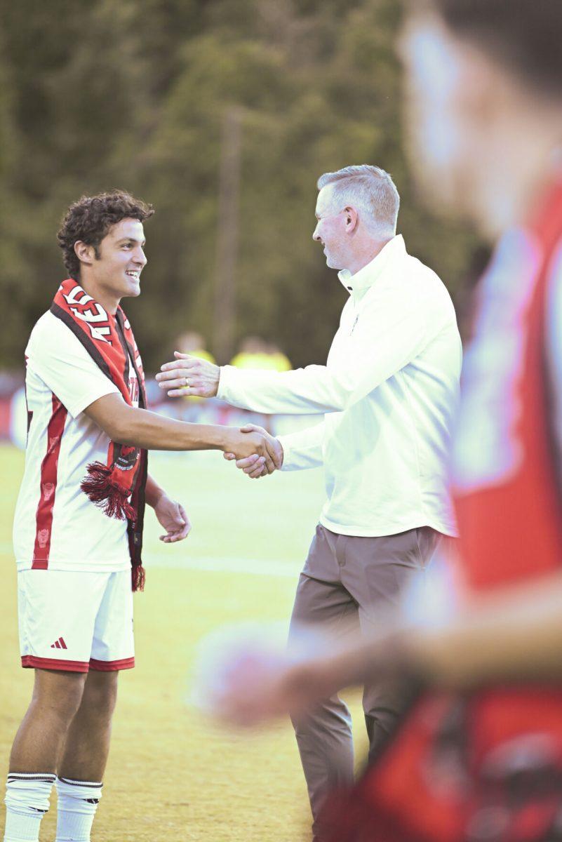 Fifth year midfielder Adam Fam shakes hands with head coach Marc Hubbard during senior night before NC State's againsts SMU at Dail Soccer Field on Saturday, Oct. 19, 2024. NC State beat SMU 5-1.