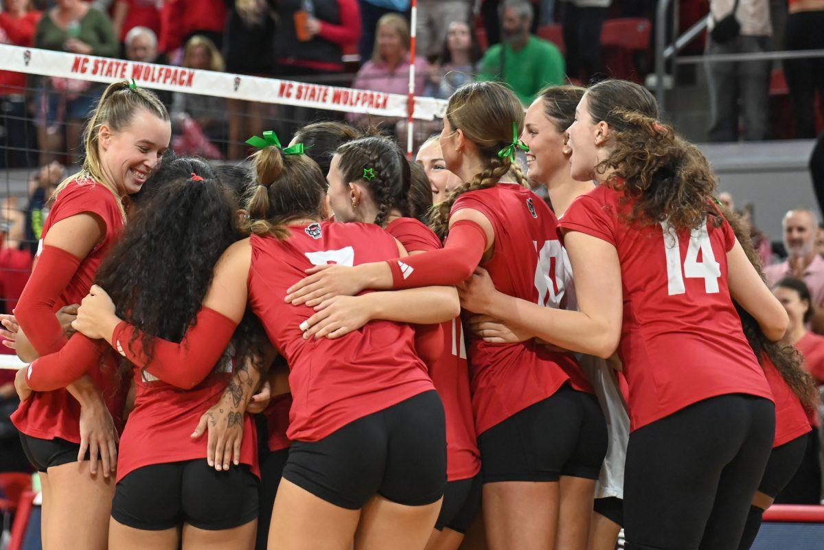 The NC State volleyball team joyously hug each other after the match against UNC-Chapel Hill on Friday, Oct. 11, 2024. The Wolfpack defeated the Tar Heels 3-1.