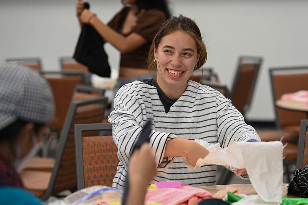 Maria Llerenas Soto, a fourth-year studying international studies, smiles while working on a clown collar at Spooky Stitches at Witherspoon Student Center on Thursday, Oct. 24, 2024. Organized by the Sustainability Stewards, Spooky Stitches was an event that encouraged students to make Halloween costumes by upcycling reused textiles and clothing.