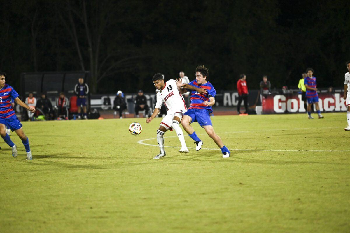 Junior midfielder Calem Tommy shields the ball against a SMU defender at Dail Soccer Field on Saturday, Oct. 19, 2024. NC State beat SMU 5-1.