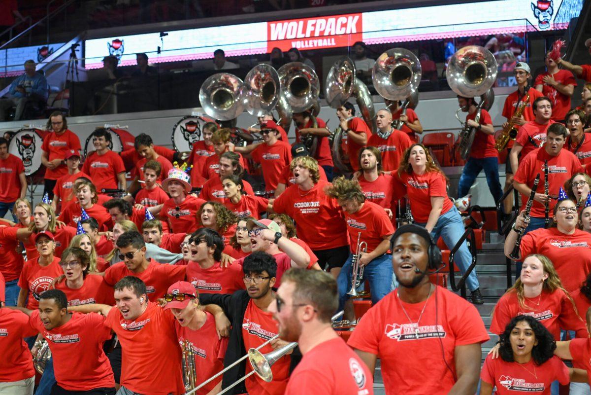 The Wolfpack Band excitedly dance on the bleachers after the volleyball team earns a point during the match against UNC-Chapel Hill on Friday, Oct. 11, 2024. The Wolfpack defeated the Tar Heels 3-1. The Wolfpack Band was present at the game in support of the volleyball team along with a record-breaking crowd.