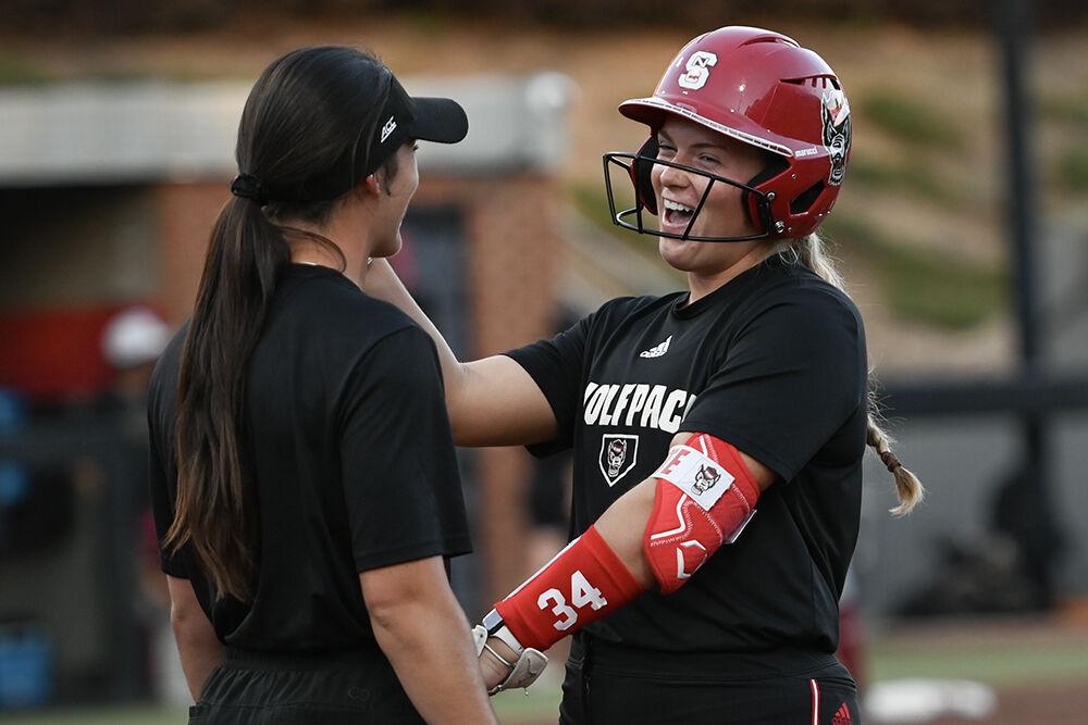 Redshirt senior catcher Payden Bordeau dances with assistant coach Grayson Radcliffe after securing first base during the game against Elon at Dail Softball Stadium on Wednesday, Oct. 23, 2024. The Wolfpack won the game 14-7.