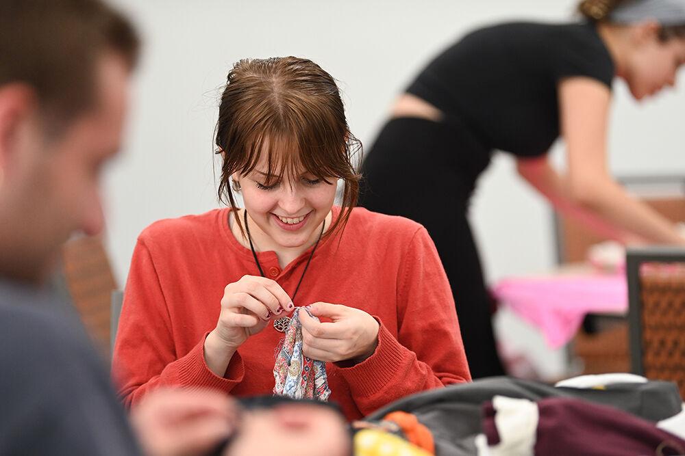 Kelly Burger, a second-year studying aerospace engineering, smiles while sewing at Spooky Stitches at Witherspoon Student Center on Thursday, Oct. 24, 2024. Organized by the Sustainability Stewards, Spooky Stitches was an event that encouraged students to make Halloween costumes by upcycling reused textiles and clothing.