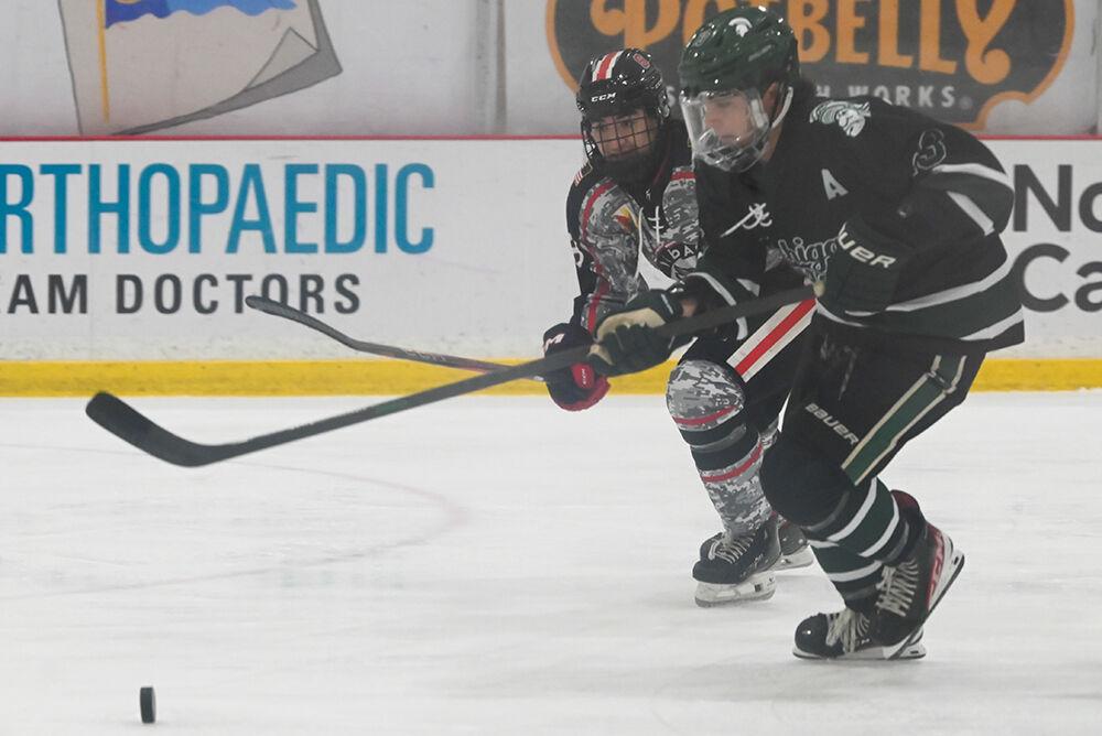 Sophomore forward Holden Koufman chases the puck alongside an opponent during the game against Michigan State at the Invisalign Arena on Friday, Nov. 8, 2024. NC State beat Michigan State 4-2.