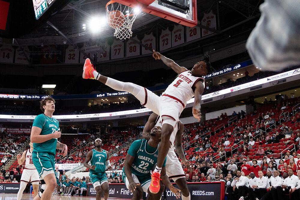 Freshman guard Trey Parker takes a big fall while shooting during the game against Coastal Carolina in the Lenovo Center on Wednesday, Nov. 13, 2024. Parker made the shot and the following free-throw, scoring 13 points for the Wolfpack. NC State won the game 82-70.