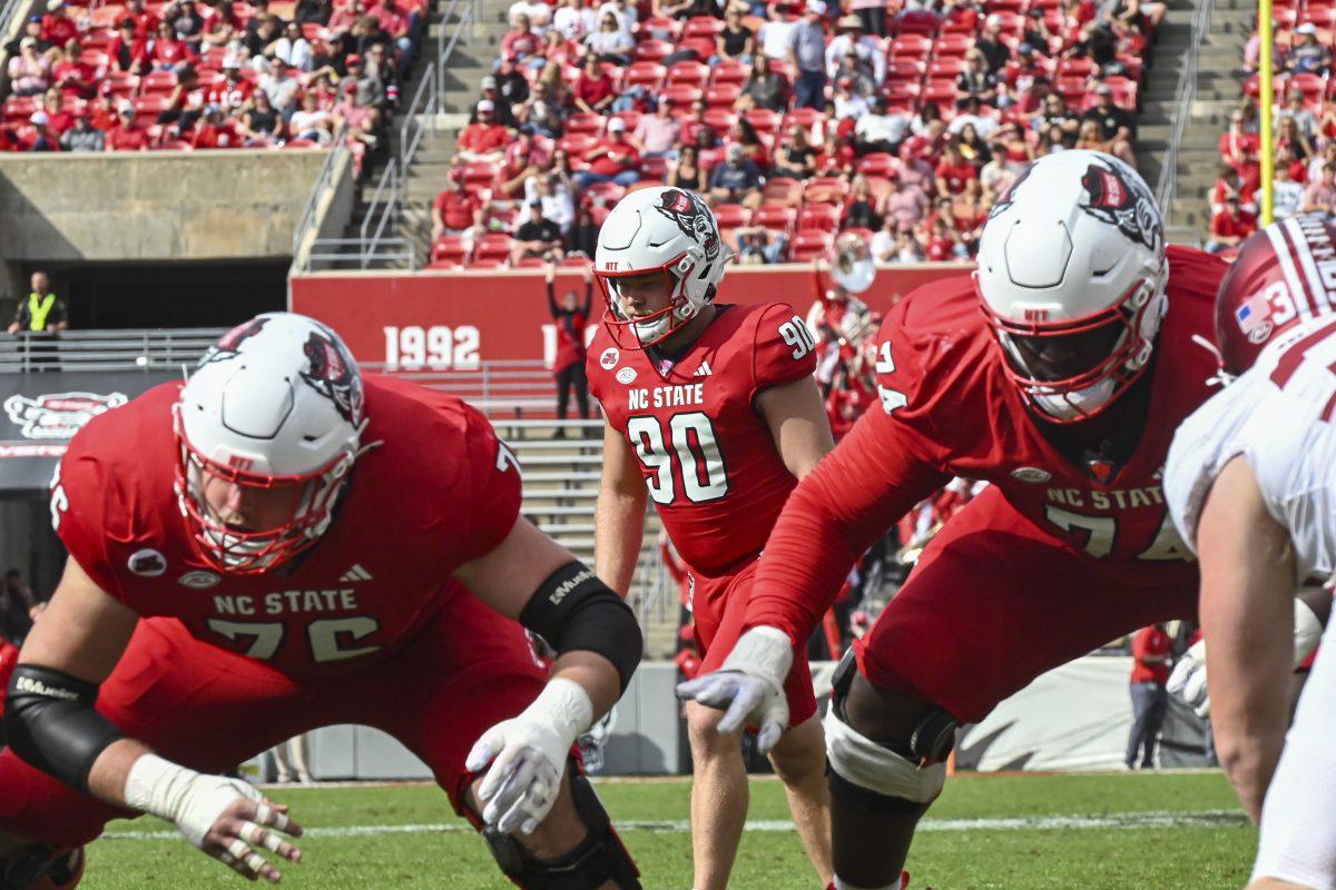 Graduate offensive lineman Patrick Matan, graduate place kicker Collin Smith, and graduate offensive tackle Anthony Belton set up for a field goal during the game against Stanford at Carter-Finley Stadium on Saturday, Nov. 2, 2024. Smith scored 11 points during the game. State beat Stanford 59-28.