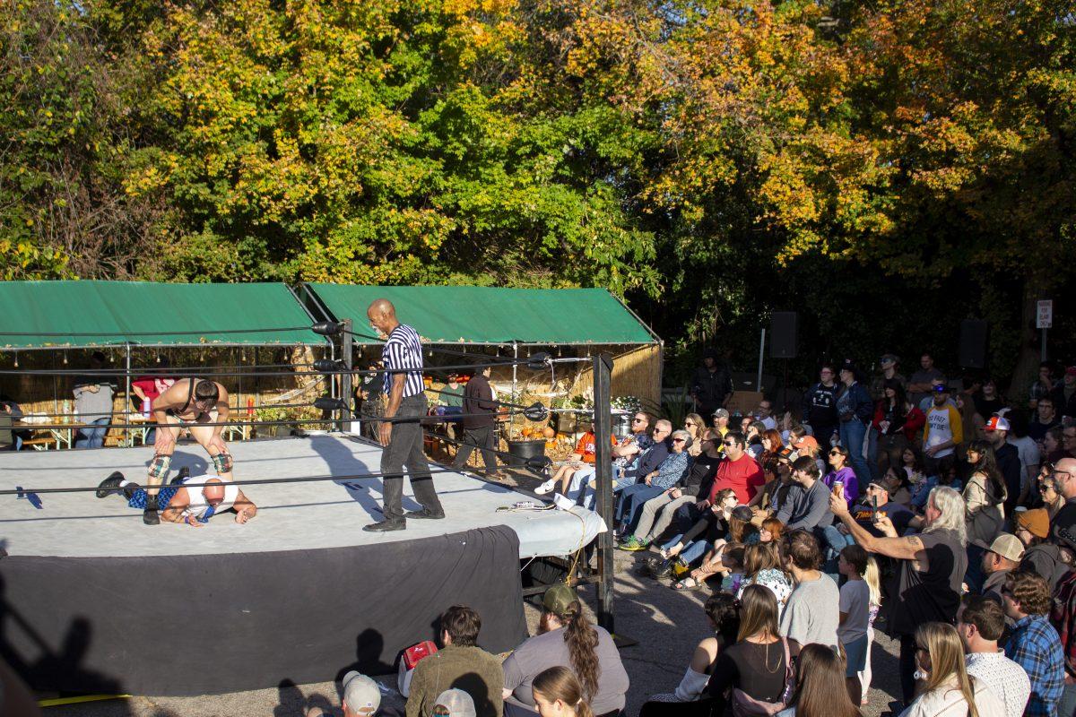 Wrestler Sawdust pushes wrestler Seymour Snott to the ground as the crowd watches during the Collison Under the Bridge event at Rebus Works coffee shop on Saturday, Nov. 9, 2024. The event, hosted by Rebus Works in downtown Raleigh, featured wrestlers from G.O.U.G.E. Wrestling. G.O.U.G.E Wrestling is an independent wrestling organization that takes a comedic spin on popular wrestling gimmicks.