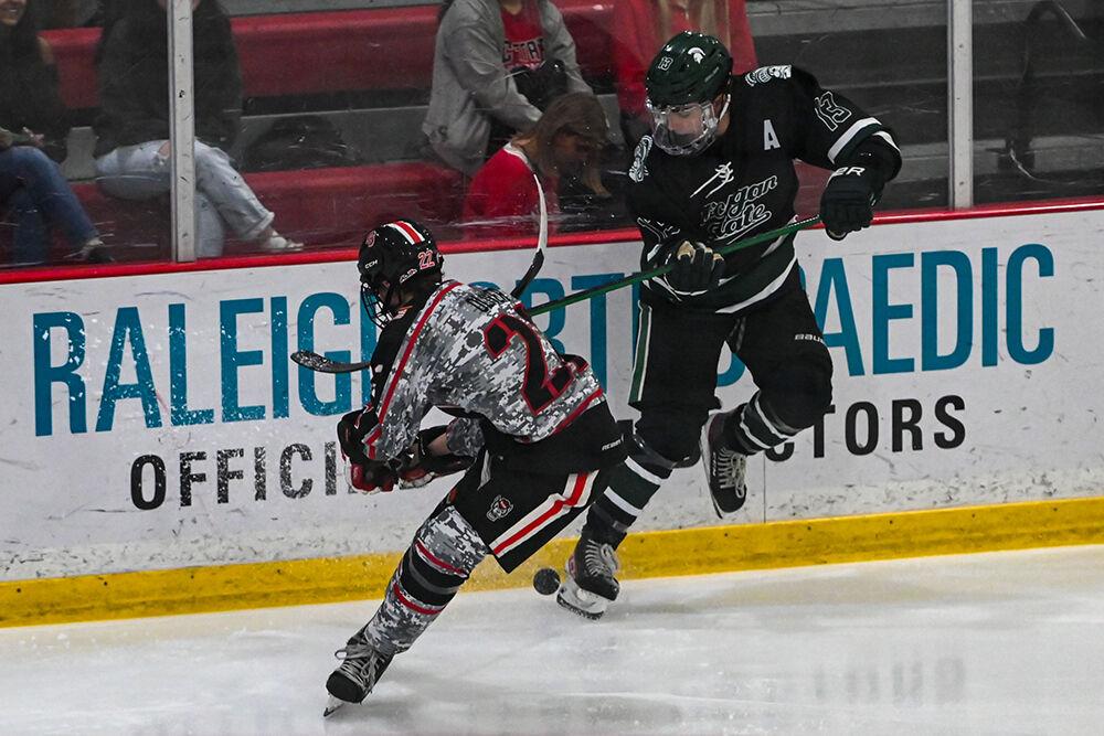Senior forward Emery Oliver fights for the puck during the game against Michigan State at the Invisalign Arena on Friday, Nov. 8, 2024. NC State beat Michigan State 4-2.