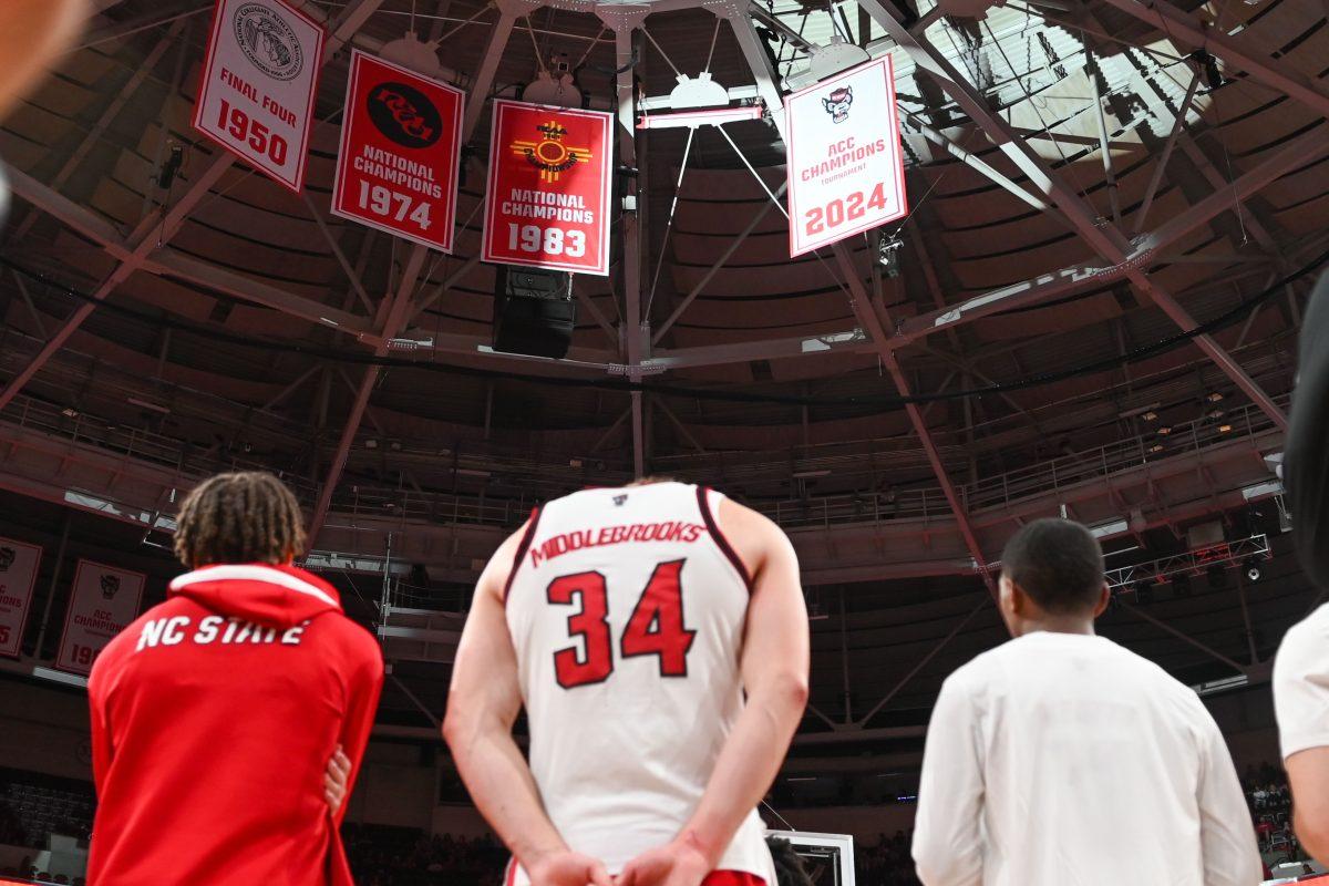 Members of the NC State Men's Basketball team watch as their ACC Championship banner is unveiled before the game against USC Upstate in the Lenovo Center on Monday, Nov. 11, 2024. NC State defeated USC Upstate 97-66.
