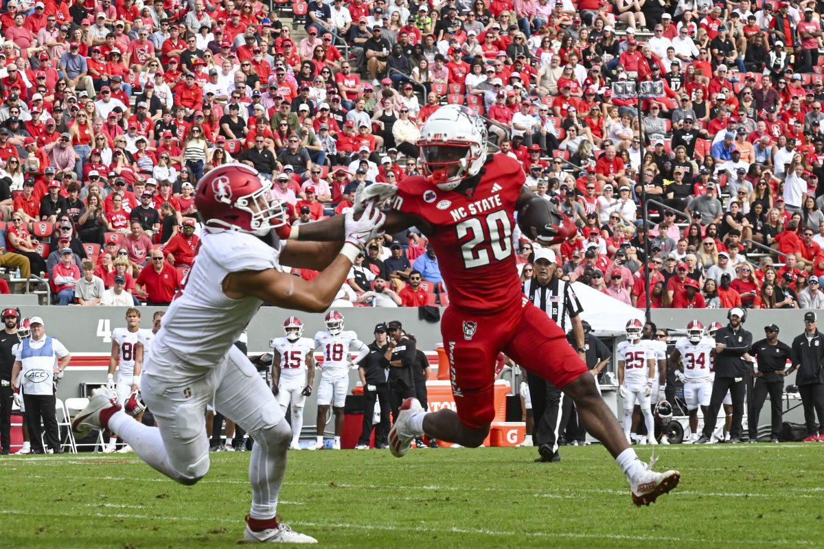Redshirt Freshman running back Hollywood Smothers stiff arms his opponent during the game against Stanford at Carter-Finley Stadium on Saturday, Nov. 2, 2024. Hollywood had 16 rushing attempts during the game. State beat Stanford 59-28.
