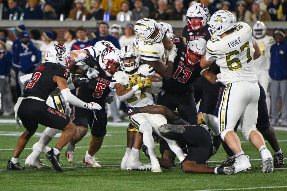 The NC State defense attempts to stop a rushing attempt during the game against Georgia Tech in Bobby Dodd Stadium at Hundai Field in Atlanta on Thursday, Nov. 21, 2024. NC State lost to Georgia Tech 30-29.