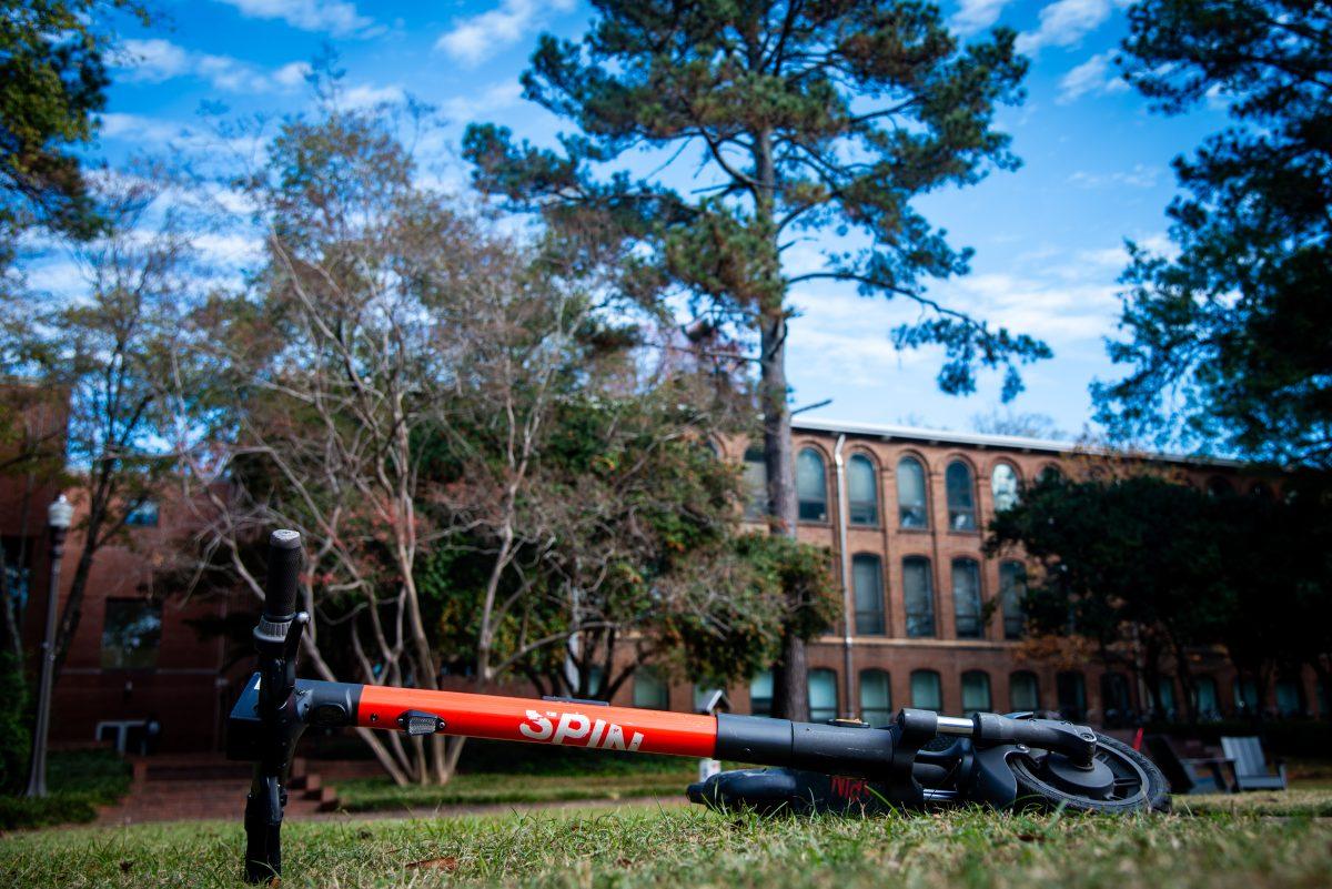 A Spin electric scooter lies sideways in the court of North Carolina on Monday, Nov. 18, 2024. Spin is a leading micromobility company and a unit of Ford Mobility, currently operating electric scooters in many cities and universities nationwide. At NC State, Spin scooters are deployed on North, Central, South, and Centennial Campuses.