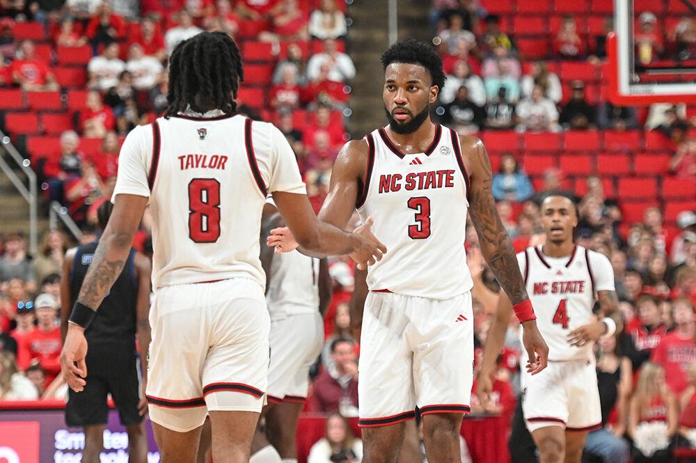 Senior guard Jayden Taylor (left) high-fives senior guard Dontrez Styles (right) during the game against Presbyterian in the Lenovo Center on Friday, Nov. 8, 2024. The Wolfpack beat the Blue Hose 81-72.