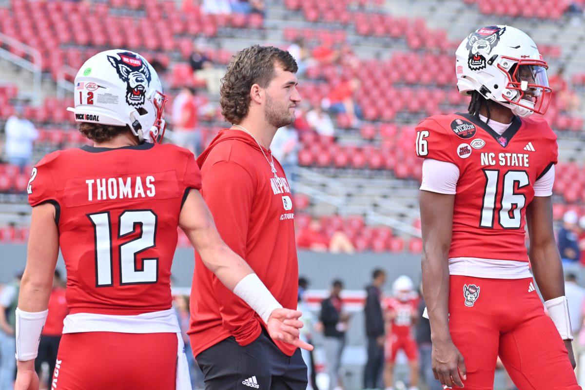 Redshirt freshman quarterback Lex Thomas, graduate retired quarterback Grayson McCall and Freshman quarterback CJ Bailey warm up prior to NC State's game against Stanford in Carter-Finley Stadium on Saturday, Nov. 2, 2024. The Wolfpack beat the Cardinal 59-28.