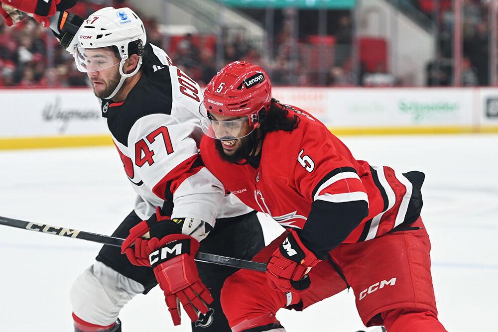 Defenseman Jalen Chatfield guards an opponent during the Hurricanes game against&#160;the New Jersey Devils at Lenovo Center on Tuesday, Oct. 15, 2024. The Hurricanes beat the Devils 4-2.