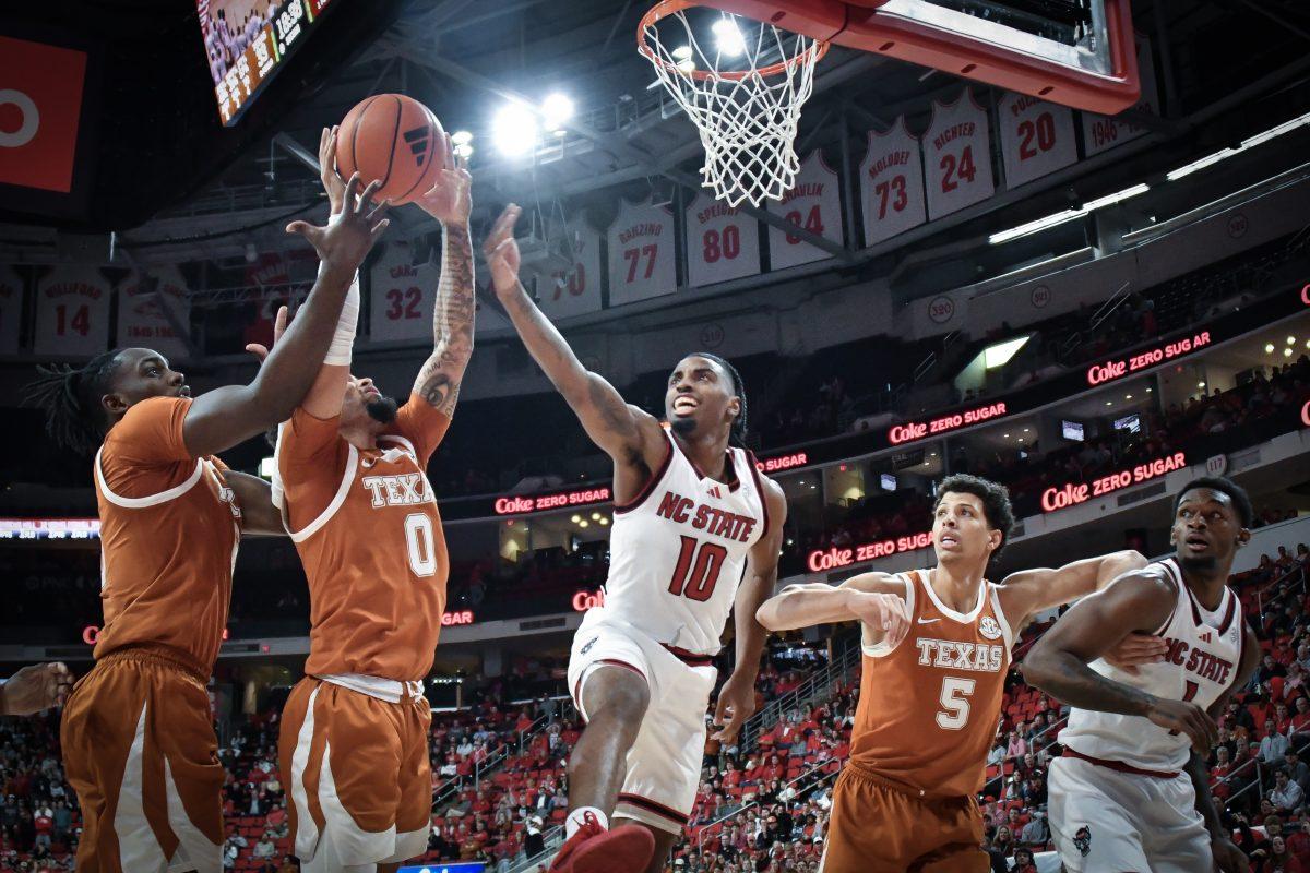 NC State senior guard Marcus Hill and senior forward Brandon Huntley-Hatfield compete for a rebound during the Wolfpack's home game against the Texas Longhorns at the Lenovo Center on Wednesday, Dec. 4, 2024. The Longhorns out rebounded the Wolfpack by 11 in the second half. The Longhorns beat the Wolfpack 63-59.