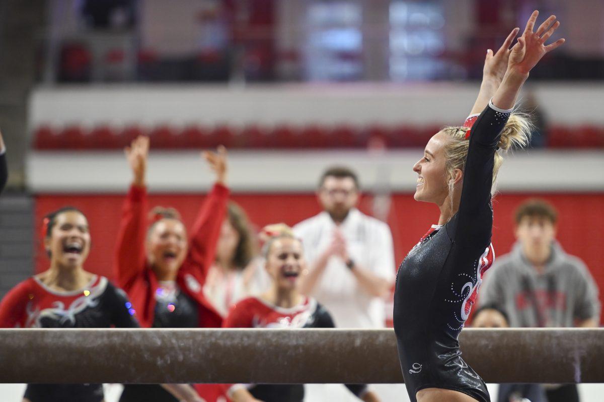 Senior Brooke Smead salutes at the end of her balance beam routine during the gymnastics team's Red and White Exhibition in Reynolds Coliseum on Sunday, Dec. 15, 2024. The red team&#160;beat the white team 11-9.