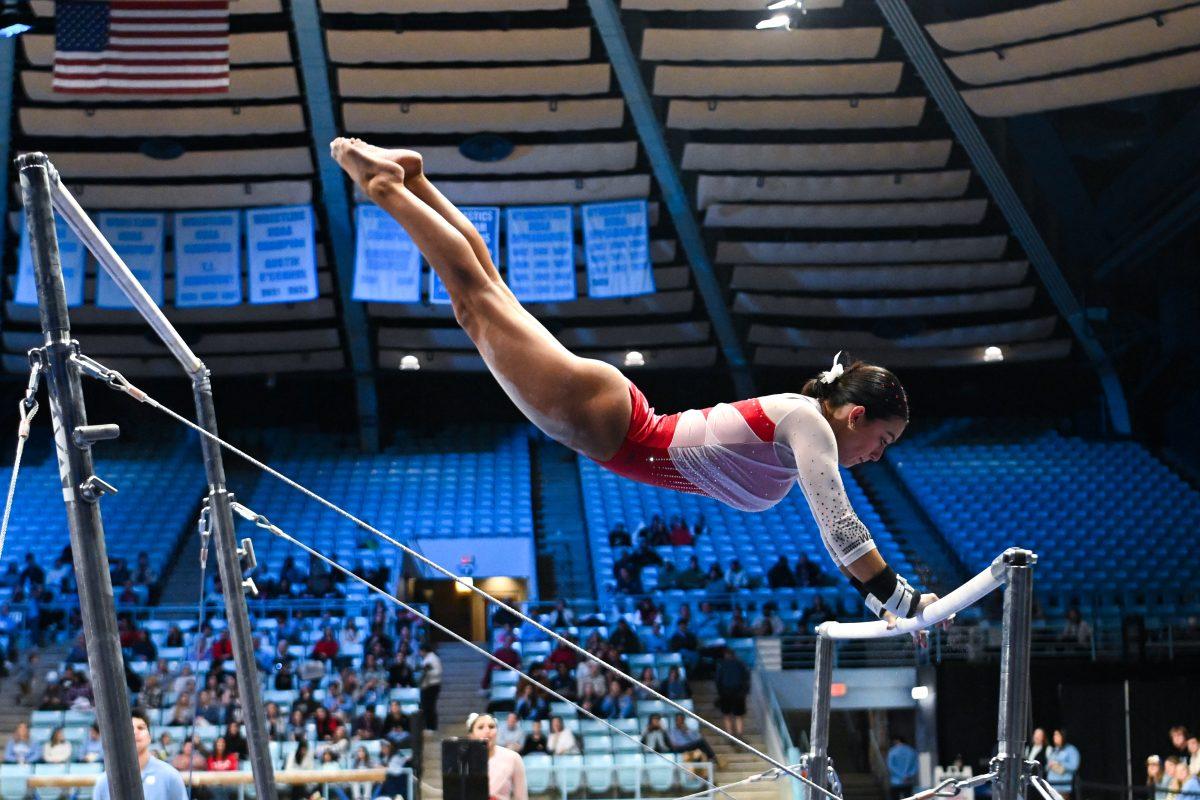 Junior Madeline Reid transitions between the uneven bars during the meet against UNC-Chapel Hill in Carmichael Arena on Friday, Jan. 24, 2025. Reid earned a 9.750 on the uneven bars. The Wolfpack beat the Tar Heels 196.350-195.925.
