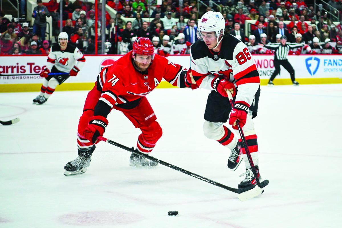 Defenseman Jaccob Slavin battles an opponent for the puck during the game versus the New Jersey Devils at Lenovo Center on Saturday, Dec. 28, 2024. The Hurricanes beat the Devils 5-2.