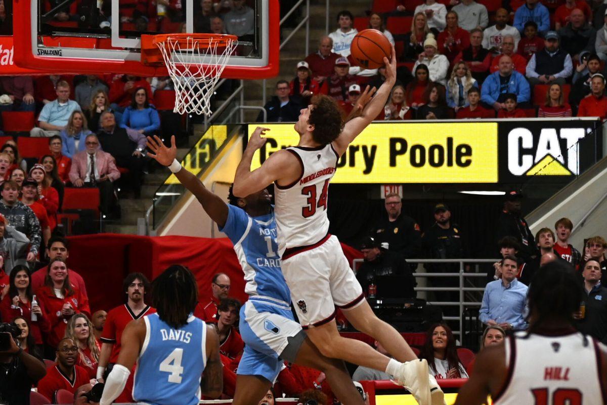 Senior forward Ben Middlebrooks reaches over a defender during the game against UNC-Chapel Hill at the Lenovo Center on Saturday, Jan. 11, 2025. Middlebrooks recovered a total of 14 rebounds throughout the game. NC State was defeated by UNC-Chapel Hill 63-61.