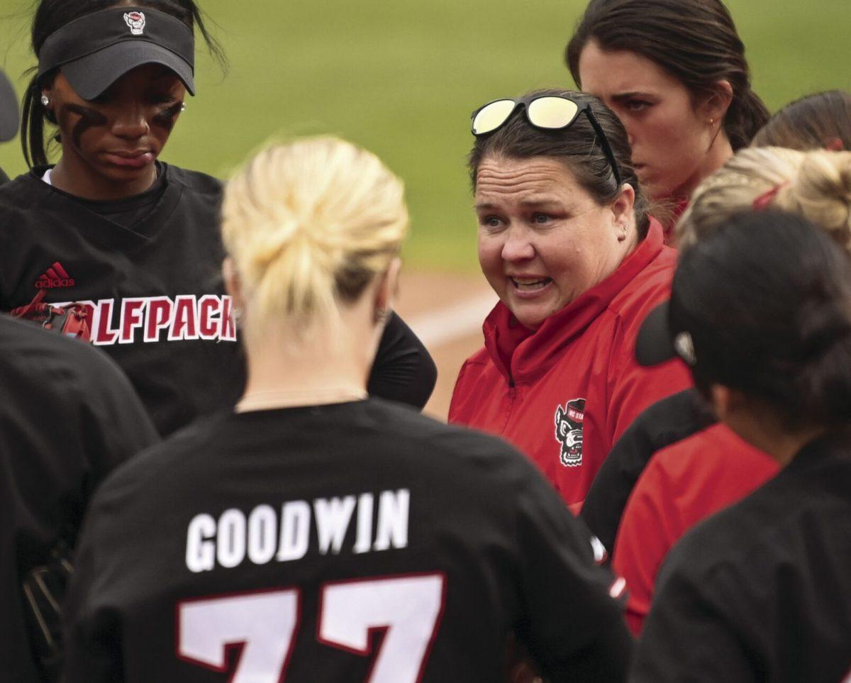 Head coach Lindsay Leftwich talks to the team between innings during the Wolfpack's softball game against the Queens University Royals at the Dail Softball Stadium on Tuesday, April 9, 2024. The Wolfpack defeated the Royals in the first game of the doubleheader 7-1.