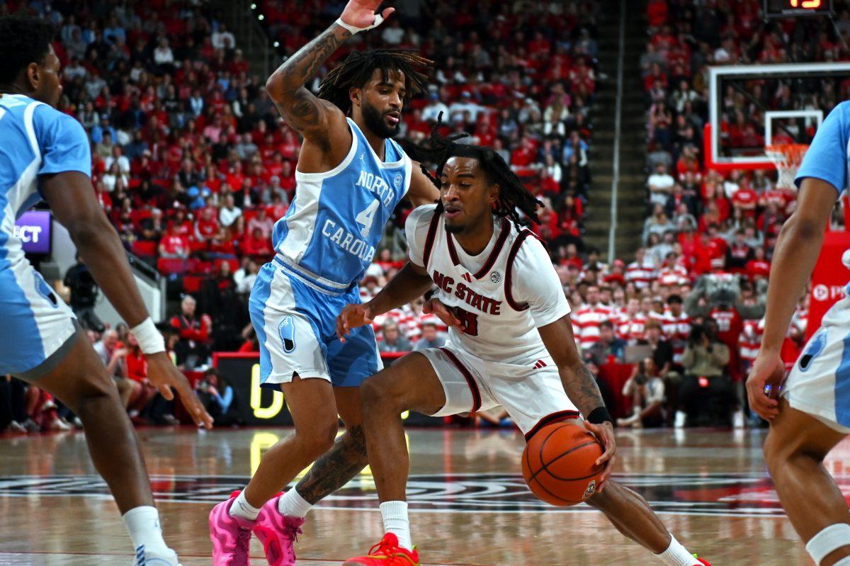 Senior guard Jayden Taylor pushing through graduate guard RJ Davis during the game against the UNC Tar Heels at the Lenovo Center on Saturday, Jan. 11, 2025. Taylor scored a total of 12 points during the game. The Tar Heels beat the Wolfpack 63-61.